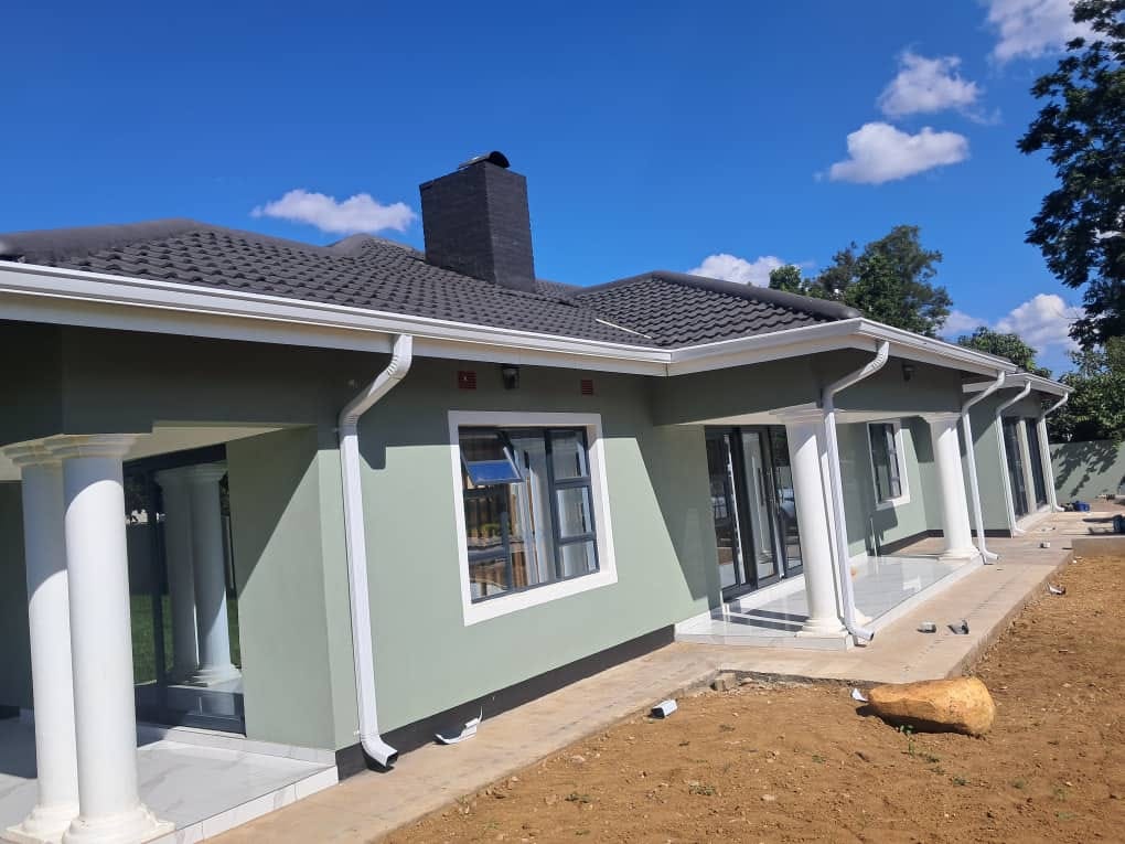 Completed white gutter system on a tiled residential roof