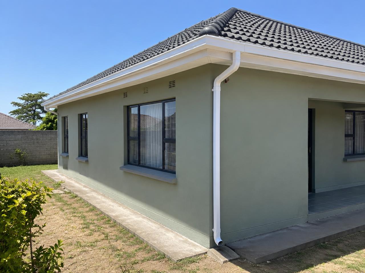 White gutter and downpipe system on a tiled residential roof